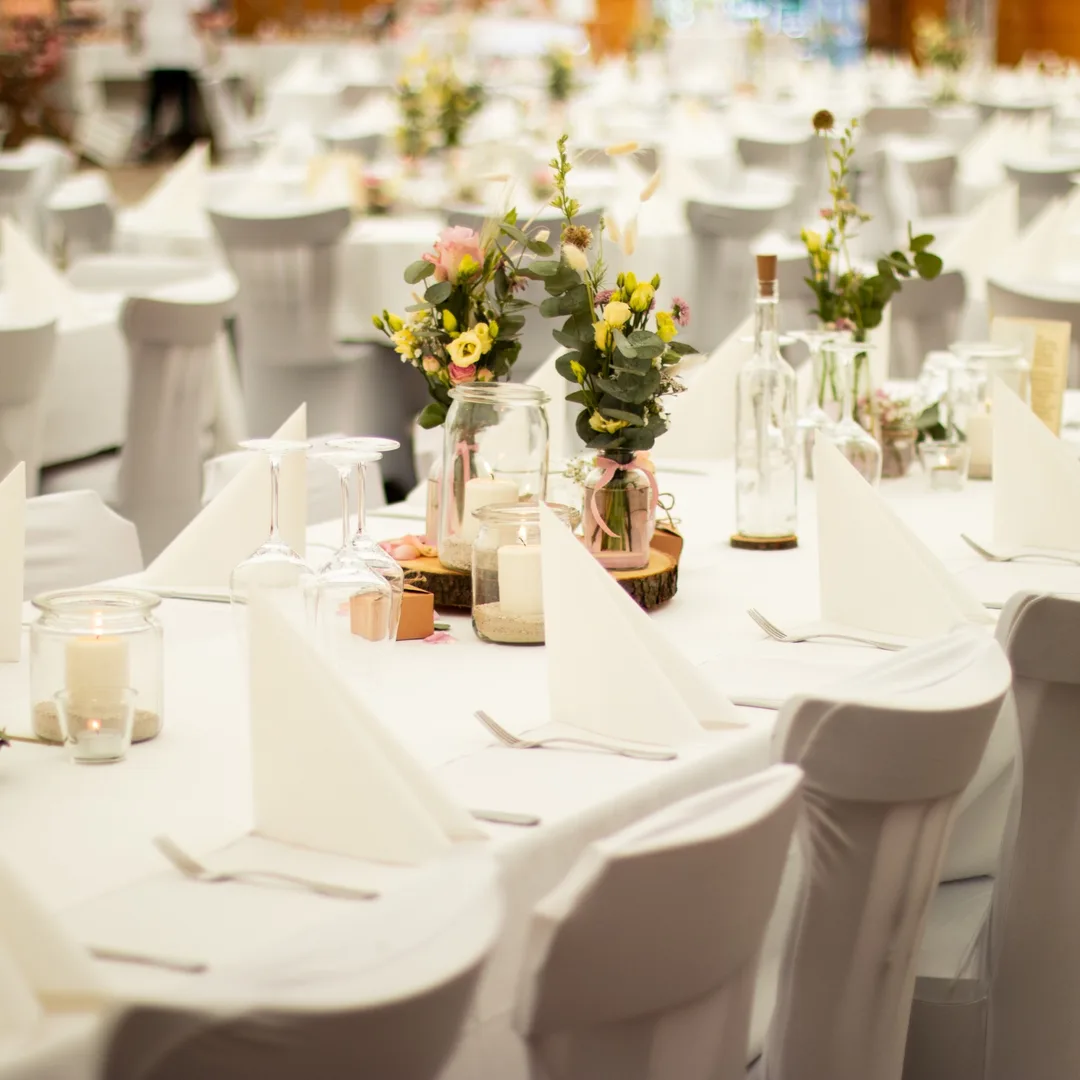 Festlich eingedeckte Hochzeitstafel mit weißen Hussen, Blumen und Kerzen im Langenhorster Hof